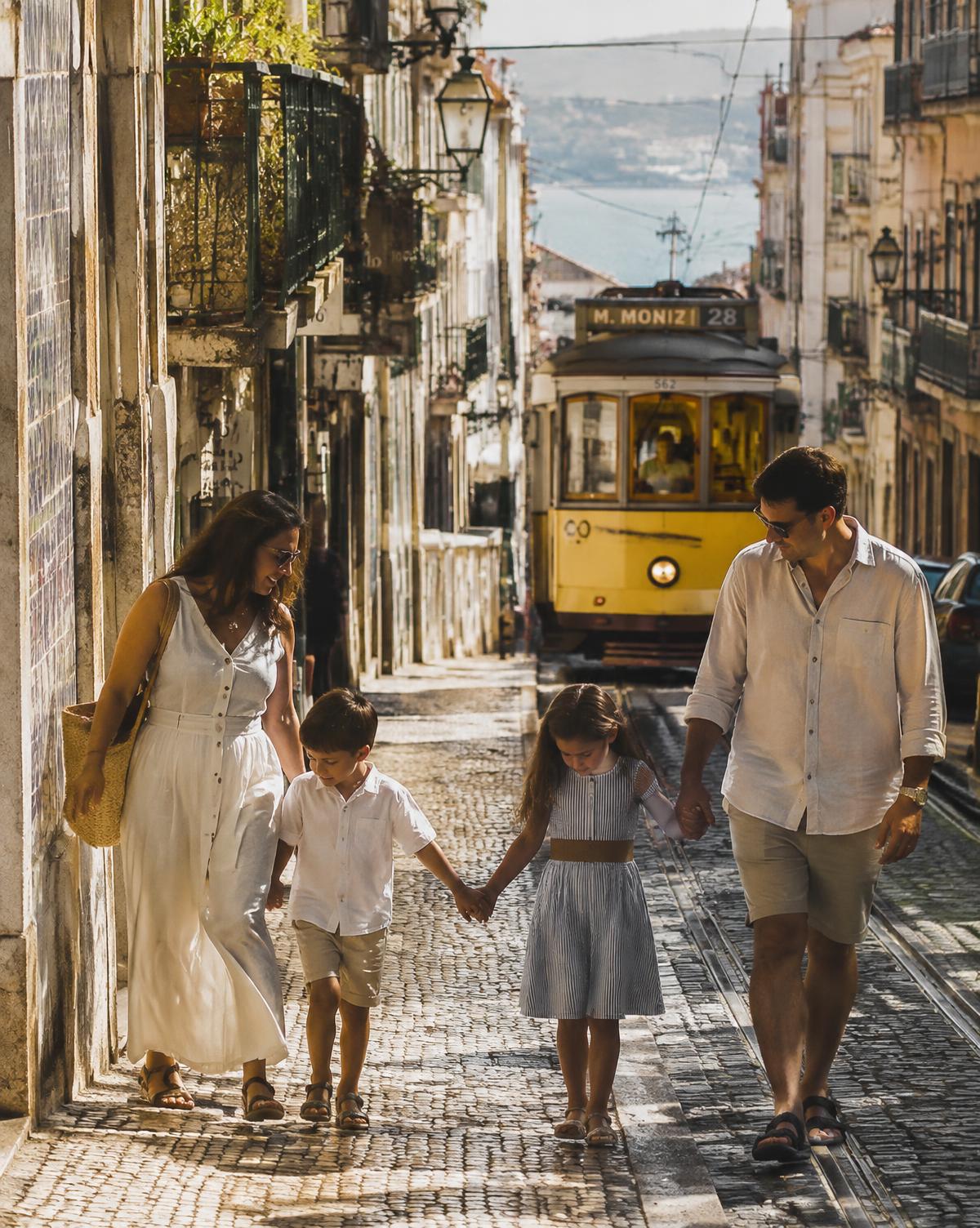 Família caminhando por rua histórica de Lisboa